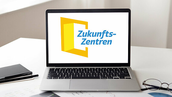 Ein Laptop, auf dessen Bildschirm das Logo der Zukunftszentren zu sehen ist.